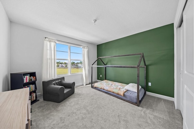 bedroom with carpet flooring, a textured ceiling, and a closet