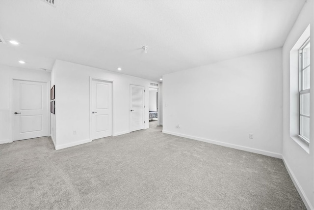 unfurnished room featuring light carpet