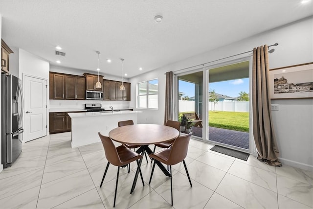 dining space with a textured ceiling and sink