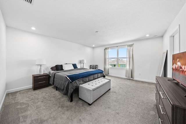 bedroom featuring light colored carpet and a textured ceiling