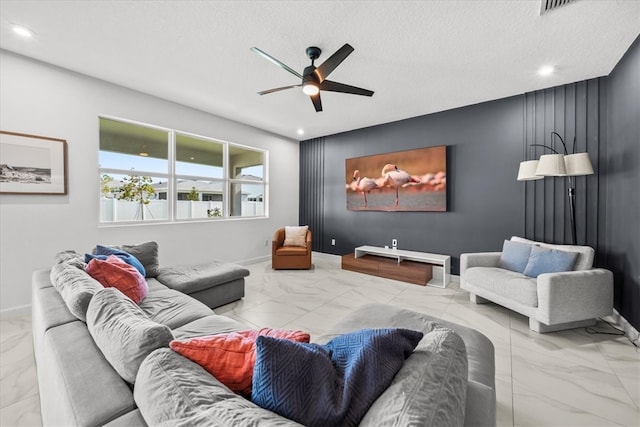 living room with a textured ceiling and ceiling fan