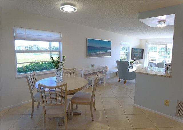 tiled dining space featuring a textured ceiling