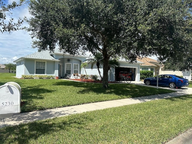 ranch-style home featuring a garage and a front lawn