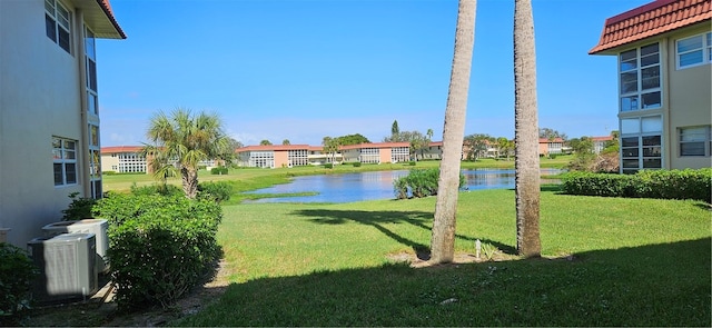 view of yard featuring central air condition unit and a water view