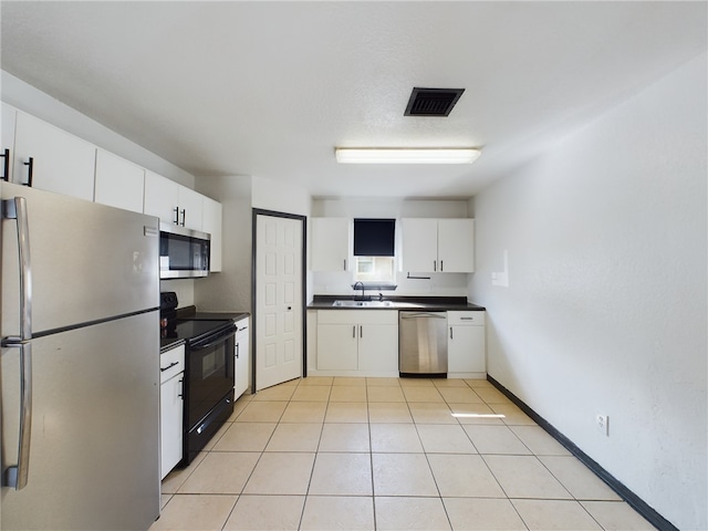 kitchen featuring stainless steel appliances, white cabinetry, sink, and light tile patterned floors