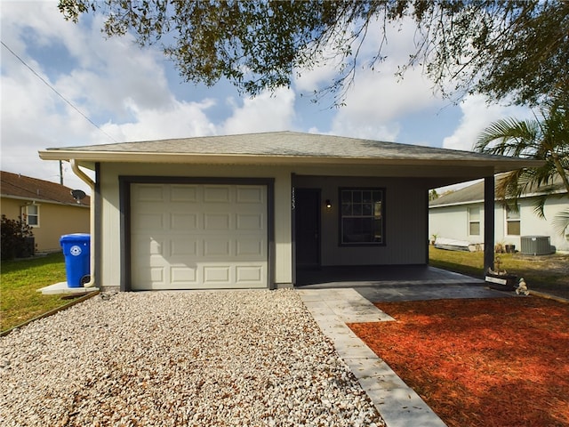 ranch-style home featuring central AC unit and a garage