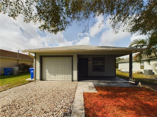 ranch-style home featuring a garage and central air condition unit