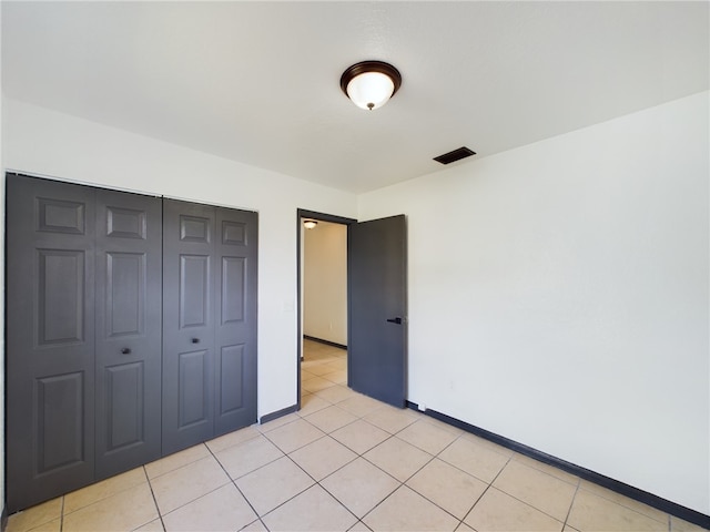 unfurnished bedroom featuring light tile patterned floors and a closet