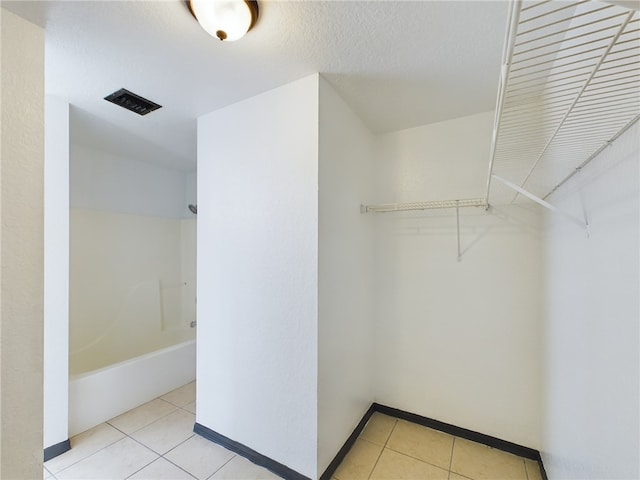 spacious closet with light tile patterned floors