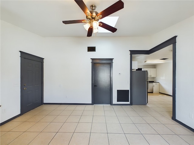 tiled empty room featuring ceiling fan