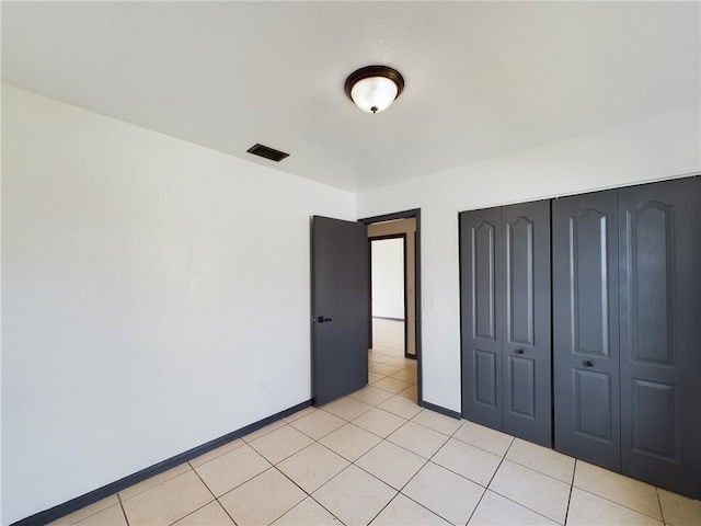 unfurnished bedroom featuring a closet and light tile patterned flooring