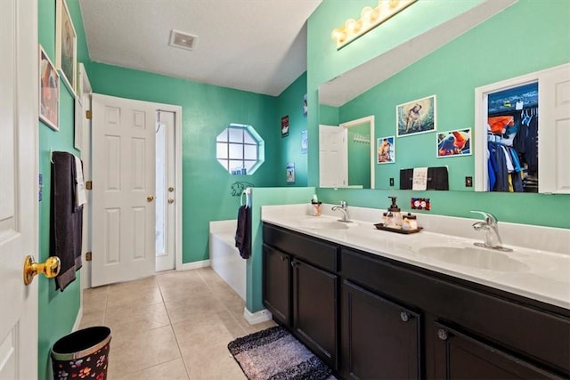 bathroom featuring tile patterned flooring, vanity, and a bathing tub