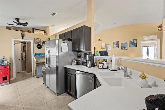 kitchen with sink, vaulted ceiling, light tile patterned floors, ceiling fan, and stainless steel appliances