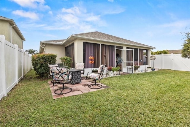 back of property featuring a yard, a patio area, and a sunroom