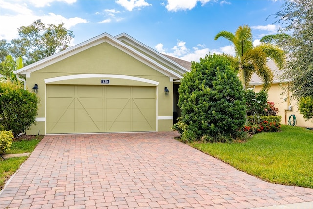 single story home featuring a garage and a front lawn