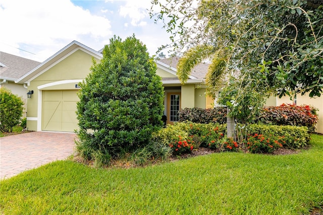 obstructed view of property with a front lawn and a garage