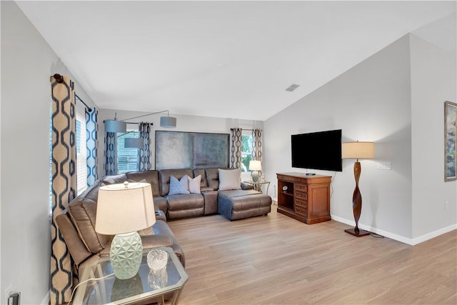 living room with light hardwood / wood-style floors and lofted ceiling