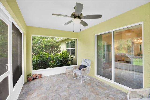 unfurnished sunroom with ceiling fan