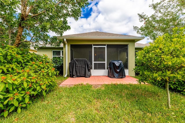 rear view of house featuring a sunroom and a lawn