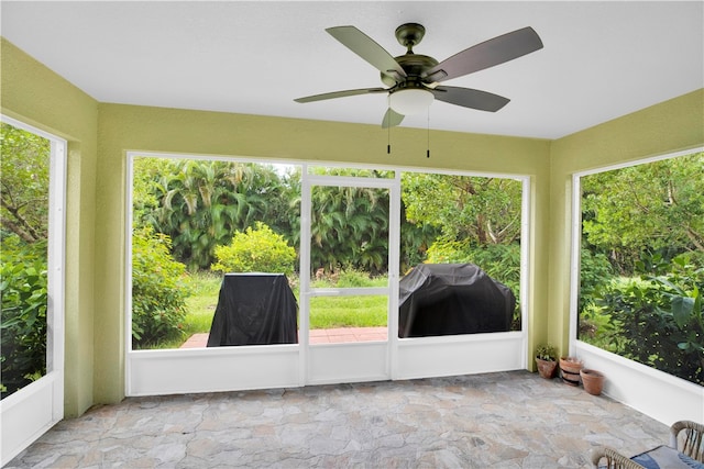 unfurnished sunroom featuring a wealth of natural light and ceiling fan