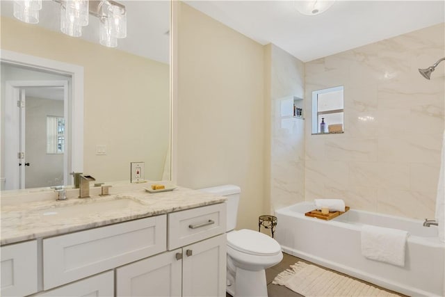 full bathroom featuring tiled shower / bath, vanity, and toilet