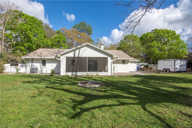 rear view of house with a sunroom and a lawn