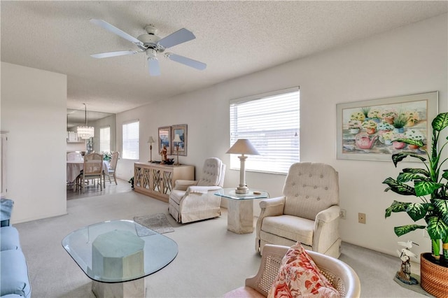 carpeted living room featuring plenty of natural light, ceiling fan, and a textured ceiling