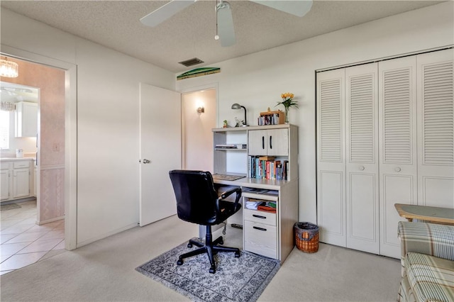 carpeted office space featuring ceiling fan and a textured ceiling