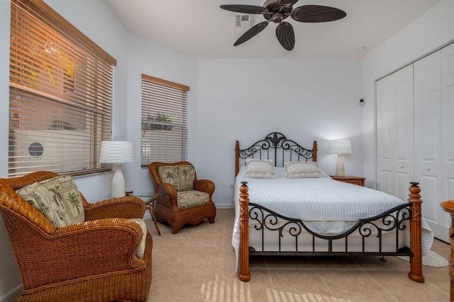 tiled bedroom featuring ceiling fan and a closet