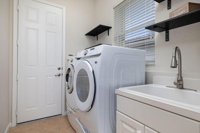 clothes washing area featuring light tile patterned floors, washing machine and dryer, and sink