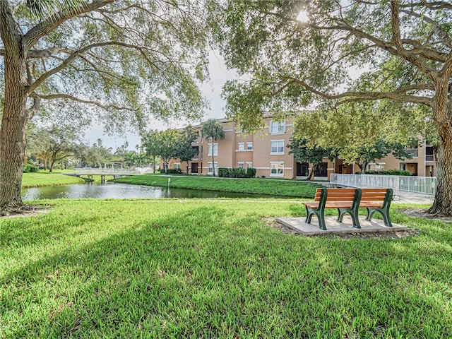 view of community featuring a lawn and a water view