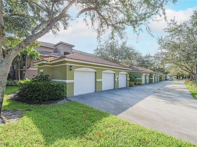 view of side of property featuring a lawn and a garage