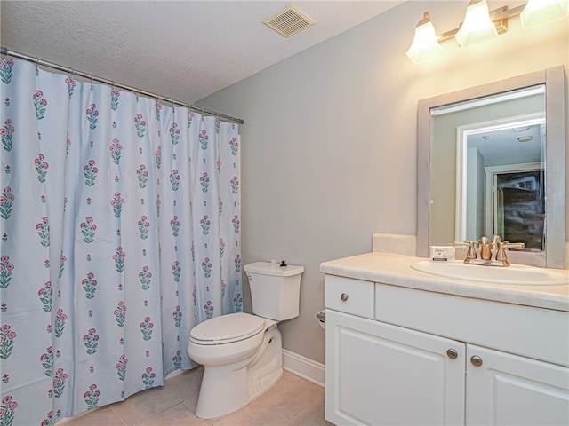 bathroom with toilet, vanity, a textured ceiling, and tile patterned floors