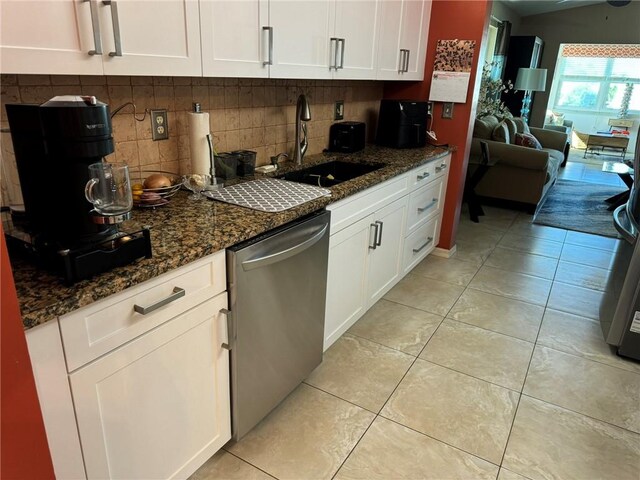625 W Lake Jasmine Cir Unit 208, Vero Beach, FL 32962 - kitchen with stainless steel dishwasher, a sink, decorative backsplash, dark stone countertops, and white cabinetry