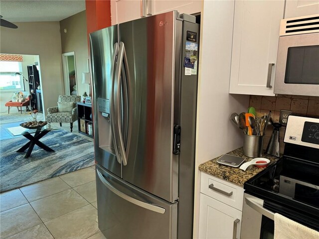 625 W Lake Jasmine Cir Unit 208, Vero Beach, FL 32962 - kitchen with appliances with stainless steel finishes, white cabinets, decorative backsplash, dark stone countertops, and light tile patterned floors