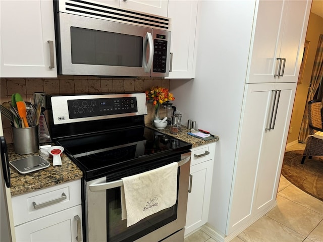 kitchen featuring dark stone countertops, white cabinets, and stainless steel appliances