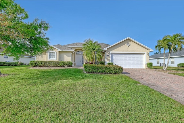 single story home featuring decorative driveway, an attached garage, a front yard, and stucco siding