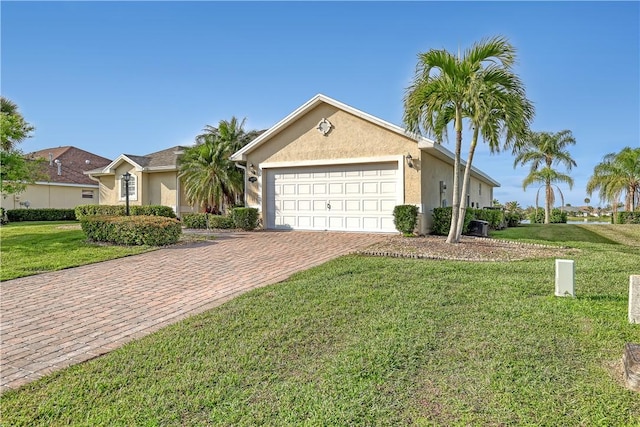 single story home featuring decorative driveway, an attached garage, a front yard, and stucco siding