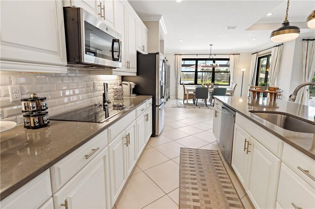 6210 Arcadia Sq, Vero Beach, FL 32966 - kitchen featuring appliances with stainless steel finishes, a sink, decorative backsplash, decorative light fixtures, and white cabinets