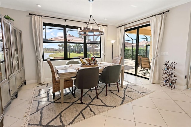 dining area with light tile patterned floors, ornamental molding, and a chandelier