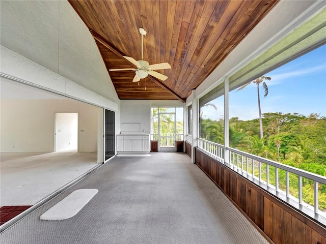 unfurnished sunroom featuring vaulted ceiling, carpet flooring, and wooden ceiling