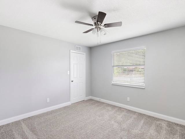 unfurnished room with a textured ceiling, ceiling fan, and carpet floors