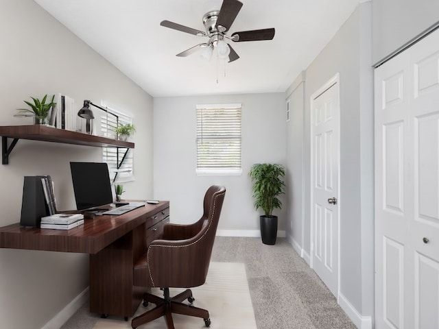 carpeted office space featuring ceiling fan