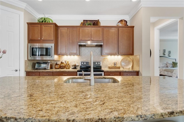 kitchen featuring light stone countertops, backsplash, stainless steel appliances, and ornamental molding