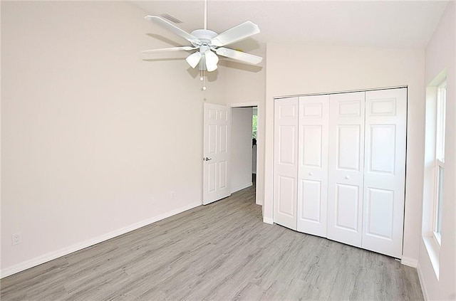 unfurnished bedroom with high vaulted ceiling, light hardwood / wood-style flooring, ceiling fan, and a closet