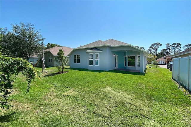 rear view of house featuring a yard