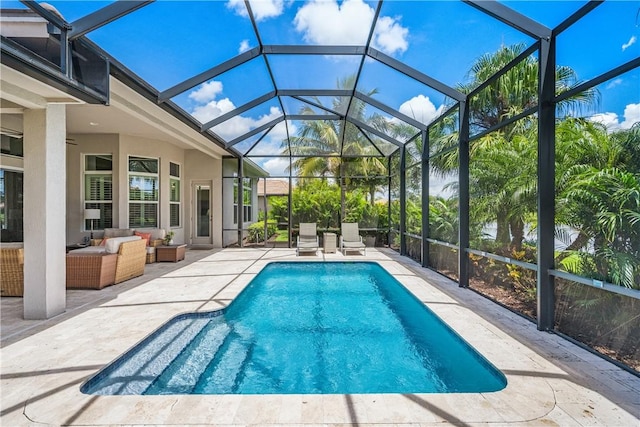 view of pool with an outdoor living space, glass enclosure, and a patio area