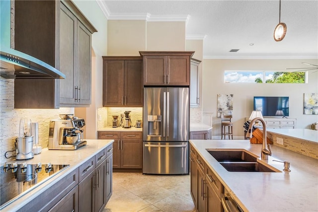 kitchen featuring wall chimney exhaust hood, sink, light tile patterned floors, appliances with stainless steel finishes, and backsplash