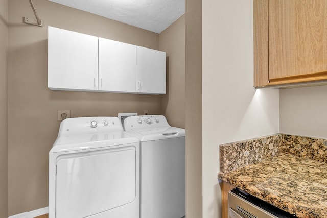 clothes washing area featuring cabinets, separate washer and dryer, and a textured ceiling