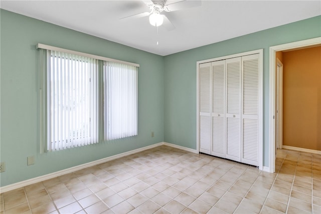 unfurnished bedroom with light tile patterned floors, ceiling fan, and a closet